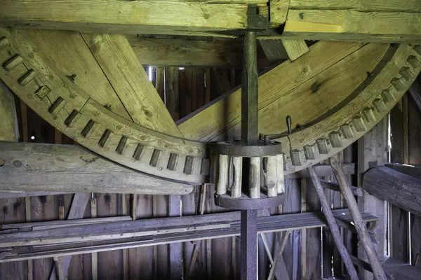 İçinde büyük ahşap bir tekerlek olan ahşap bir yapı. Tekerlek ahşap parmaklıklarla çevrilidir ve ortasında metal bir parçası vardır. Eski ve eski bir yapı gibi görünüyor, bir tarih duygusu var.