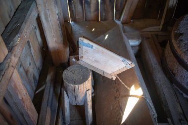 Karanlık bir odadaki kütüğün üzerinde tahta bir sandık var. Sandık kütüğe zincirle bağlanmış.