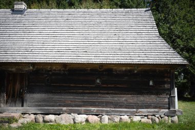 Büyük, eğimli çatısı olan eski bir bina. Çatı ahşaptan yapılmıştır ve bir sürü kiremitleri vardır. Bina çimenlik bir alanla çevrilidir.