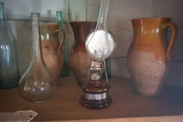 İçinde lamba ve birkaç vazo olan bir masa. Vazolar farklı boyutlarda ve renklerde.