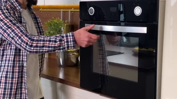 집에서 요리를 합니다 긍정적 가정의 남편은 음식을 오븐에 확인하고 냄새를 — 비디오
