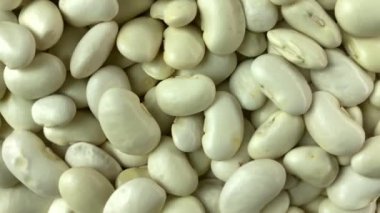 Slow Motion Rotation Raw White Beans Indoors. Macro Shot Bean Texture Pattern Background. Vegetarian Healthy Organic Food Diet Concept. Organic Kidney Bean Rotating Close-up. Studio Shot
