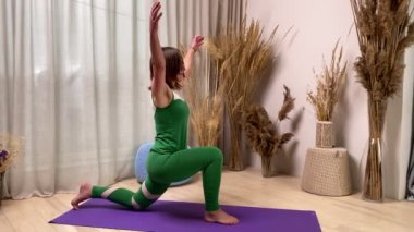 Middle-aged woman in sportswear practicing yoga mat indoors. Sporty senior female performing set of exercises, doing low lunge lizard pose at home. Healthy Lifestyle, Fitness, Wellbeing Mindfulness