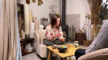 Middle-aged fortune teller in casual clothing predicting bad news male client reading mystic sign coffee grounds. Modern witch holding esoteric session, fortune telling adult man indoors. Tasseography