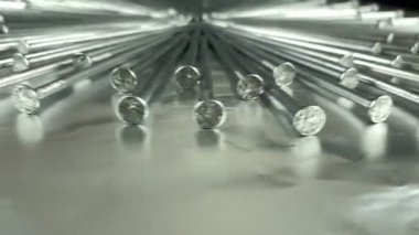 Düşük açılı monokrom stüdyo ışığı altında gümüş folyo üzerinde dönen çelik çiviler düzenledi. İnşaat alanı için düz başlı metal donanım. Keskin detaylar. Metalik tamir malzemesi. Galvanize raptiyeler