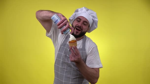 Cheerful Barbudo Macho Cozinhando Sobremesa Pulverizando Para Fora Chantilly Cupcake — Vídeo de Stock