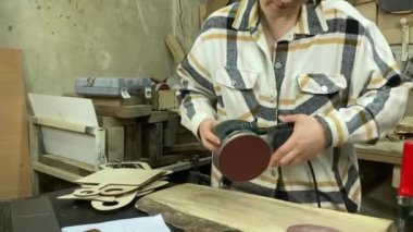 Kadın katılımcı, marangozluk, ahşap atölye. Kapalı alanda ahşap aletlerle çalışan büyüleyici bir zanaatkar. Küçük bir iş. El yapımı üretim. Diy konsepti. Ekipman, arka plandaki malzemeler