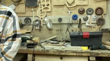 Kadın katılımcı, marangozluk, ahşap atölye. Kapalı alanda ahşap aletlerle çalışan büyüleyici bir zanaatkar. Küçük bir iş. El yapımı üretim. Diy konsepti. Ekipman, arka plandaki malzemeler