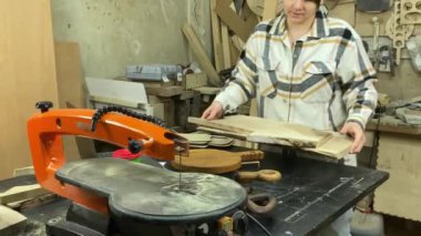 Kadın katılımcı, marangozluk, ahşap atölye. Kapalı alanda ahşap aletlerle çalışan büyüleyici bir zanaatkar. Küçük bir iş. El yapımı üretim. Diy konsepti. Ekipman, arka plandaki malzemeler