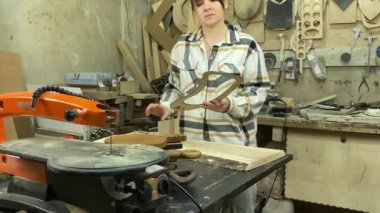 Kadın katılımcı, marangozluk, ahşap atölye. Kapalı alanda ahşap aletlerle çalışan büyüleyici bir zanaatkar. Küçük bir iş. El yapımı üretim. Diy konsepti. Ekipman, arka plandaki malzemeler