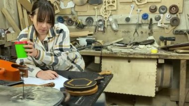 Kadın tasarımcı, marangoz, ahşap atölye. Büyüleyici bir zanaatkar. Odunları içeride çiziyor. Küçük bir iş. El yapımı üretim. Diy konsepti. Ekipman, arka plandaki malzemeler