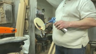 Marangozluk, ahşap atölye. İçeride yanmış ahşap malzemeler yapan tanınmayacak kadar yetenekli bir zanaatkar. Küçük bir iş. El yapımı üretim. Diy konsepti. Ekipman, arka plandaki malzemeler
