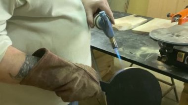 Marangozluk, ahşap atölye. İçeride yanmış ahşap malzemeler yapan tanınmayacak kadar yetenekli bir zanaatkar. Küçük bir iş. El yapımı üretim. Diy konsepti. Ekipman, arka plandaki malzemeler