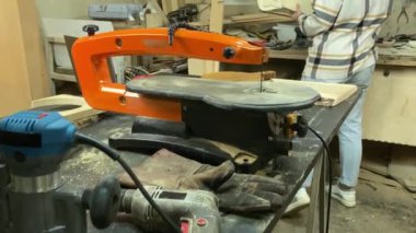 Kadın katılımcı, marangozluk, ahşap atölye. Kapalı alanda ahşap aletlerle çalışan büyüleyici bir zanaatkar. Küçük bir iş. El yapımı üretim. Diy konsepti. Ekipman, arka plandaki malzemeler
