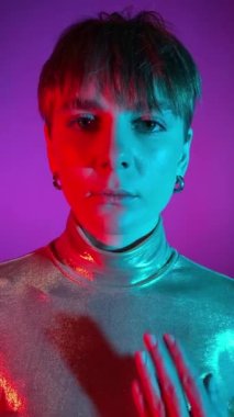 Değişken ego kavramı, ikiyüzlülük, iyi ve kötü, insan doğası. Dikey portre genç yetişkin kadın bir gözünü eliyle kapatıyor. Kadın yüzünün yarısı kırmızı ışıkta parlıyor. Renkli canlı arkaplan