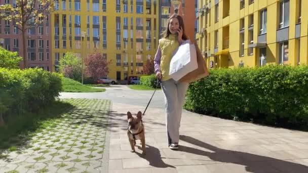Όμορφη Νεαρή Γυναίκα Πόδια Σκυλιών Κρατά Τσάντες Ψώνια Μιλάει Τηλέφωνο — Αρχείο Βίντεο