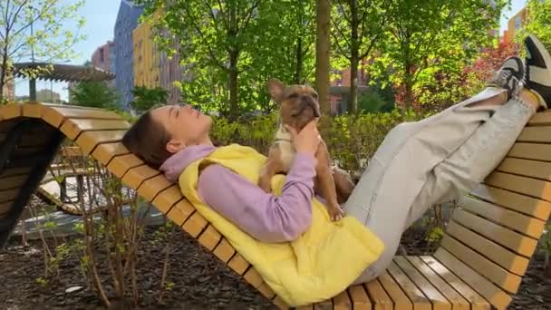 Ξέγνοιαστη Νεαρή Γυναίκα Υπέροχο Μικρό Καφέ Σκυλί Χαλαρωτικό Απολαμβάνοντας Ηλιόλουστο — Αρχείο Βίντεο