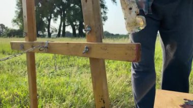 Yakışıklı olgun sanatçı modası boyayı bitirir, bez parçasıyla ellerini siler, sabah güneşinde dalgın bir şekilde dışarıdaki sanat eserlerini inceler. İyi görünümlü orta yaşlı ressam işleri değerlendiriyor.