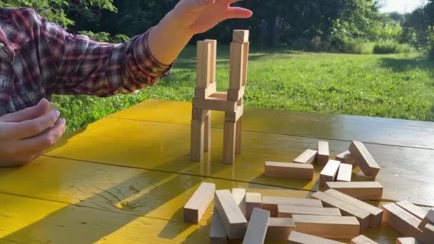 Yetişkin Bir Kadın Güneş Doğarken Sarı Masaya Tahta Bloklarla Kule — Stok video