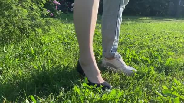 ワークライフバランスの概念 低いセクション女性は立つ半分の作業靴カジュアル靴上の緑の草で日の出 健康的なライフスタイルの選択 ビジネスシューズとスポーツシューズの女性の足 — ストック動画