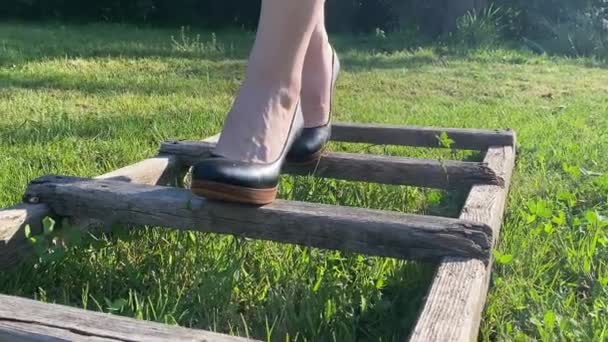 認識できない女性は日の出に屋外の木製のはしごを歩く 成功の概念のはしご ローセクションフロントビュービジネス作業靴の女性の足はキャリアパスをステップします 緑の風景背景 — ストック動画