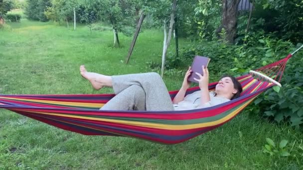 Fröhliche Erwachsene Frau Liest Ein Buch Während Sie Sich Der — Stockvideo
