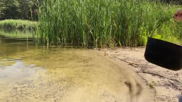 環境保全天然資源 自然に対する敬意ある態度 14歳の少女はキャンプポットを使用して新鮮なきれいな水の純粋な池を収集し 家族は晴れた日の屋外でハイキングします — ストック動画