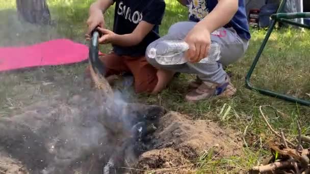 Odpowiedzialne Dzieci Przejmują Stery Starannie Gasząc Ognisko Podczas Rodzinnej Wędrówki — Wideo stockowe