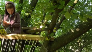 Baba ve çocuklar özel ağaç ev inşaatı projesiyle meşgul. Erkek ebeveyn, küçük oğluna çekiç kullanmayı öğreterek tahtayı çivilemeyi öğretir. Aile çalışması, işbirliği, bağlanma anları