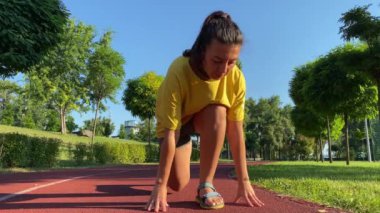 Çok ırklı genç bir kadın güne ferahlatıcı bir sabah koşusuyla başlıyor. Koşu parkurunda düşük bir başlangıç yaparak hızla koşmaya başlar. Düşük açı görünümü belirlenmiş sporcu alıştırmaları için hazır