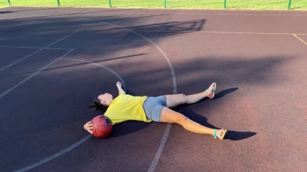 다인종 여자는 그녀의 공원의 스포츠 코트에 그녀는 농구를 햇볕이 아침에 — 비디오