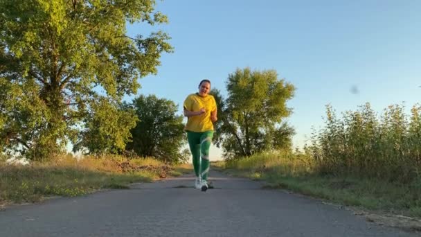 Eine Junge Frau Sportkleidung Joggt Bei Sonnenuntergang Munter Über Die — Stockvideo