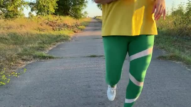 Eine Junge Frau Pulsierender Sportbekleidung Joggt Die Ruhige Landstraße Entlang — Stockvideo