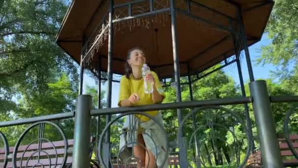 Многорасовая Молодая Женщина Отдыхает Утренней Пробежки Общественном Парке Опирается Забор — стоковое видео
