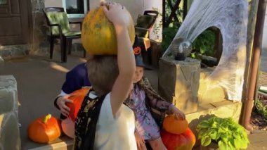 Aile verandada neşeli bir Cadılar Bayramı akşamını paylaşır. Kostümler giyer, güler geçeriz. Ev balkabaklarıyla, örümcek ağlarıyla, ürkütücü dekorasyonlarla süslenmiş, neşeli bir atmosfer yaratıyor.