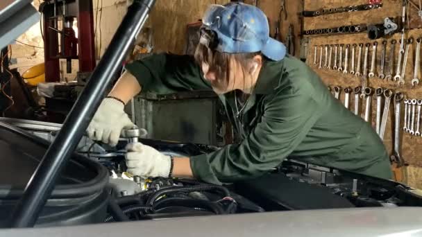 Μια Νεαρή Γυναίκα Φόρμες Εργάζεται Ένα Πρατήριο Αυτοκινήτων Εκτελεί Επισκευές — Αρχείο Βίντεο