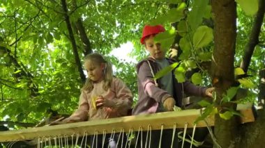 Aile bağı. Büyük açık havada birlikte vakit geçirerek çocukluğun keyfi. Baba ve ilköğretim çağındaki çocuklar neşe içinde bir ağaç ev inşa ederek harika çocukluk anıları yaratıyorlar..