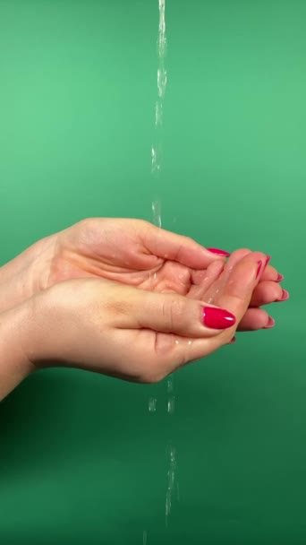 一个难以辨认的女人拿起双手 陶醉在清澈清澈的水中 概念水化 水在自我保健和身体整体健康中的重要作用 绿色的垂直室内 — 图库视频影像