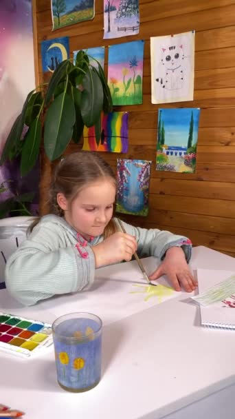 青春的艺术表达 童年的业余爱好 一个可爱的小女孩垂直地从事水彩画 在室内绘画和室内植物的背景下探索她的创造力和想象力 — 图库视频影像