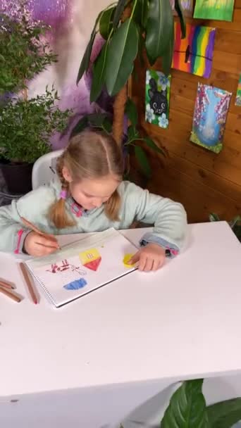 若々しい芸術的想像力 幼少期の趣味 縦の美しい少女は芸術的な供給 屋内植物に囲まれた色鉛筆で喜んで描くことによって彼女の創造性を表現します — ストック動画