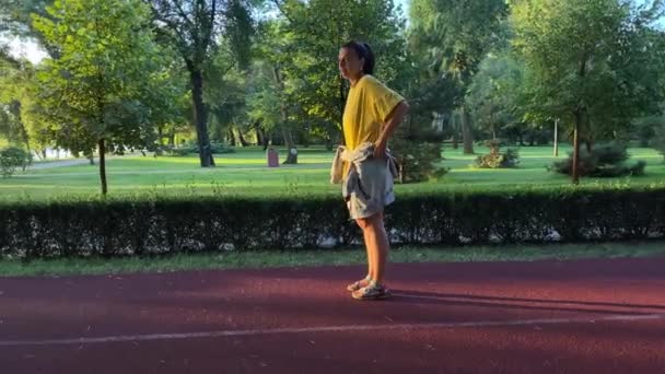 一位多种族的年轻女子喜欢在公园里晨跑 感受日出的活力 在接下来的一天里 跑步给她带来了活力 激发了她的体育爱好和自我保健精神 — 图库视频影像