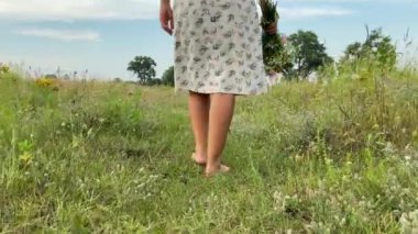 Eğlence, boş zaman, açık hava. Çok ırklı bir kadının düşük kesimi doğanın güzelliğine hayran kalır, çayırlarda gezinir, yaz otlarının ve kır çiçeklerinin tadını çıkarır.