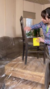 Güzel bir genç kadın ev dekorasyonuna girişiyor, bina içi inşaat malzemelerinin yenilenmesi için hazırlık yapıyor. Dikey çekim, DIY konsepti. Tamirci kadın eski mobilyaları restore ediyor.