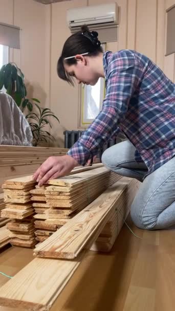 一位年轻貌美的女子正在装修房屋 准备装修室内 垂直射击 Diy概念 女服务员用胶带测量木制建筑材料 — 图库视频影像