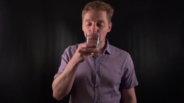 Portre tarzı genç bir adam susuzluğunu serin suyla gideriyor. Canlı mor bir gömlek giyiyordu. Günlük sakalları, zahmetsizce kalça hareketlerini tamamlıyordu. Canlandırıcı sıvı siyah fon içiyor.