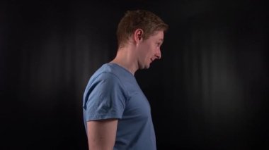 Yakışıklı genç bir adam güvenle başını sallar ve kabul ederek evet der, siyah bir fon karşısında bir onay jesti ile kabul eder. Onun portresi pozitiflik ve kararlılık yayıyor.