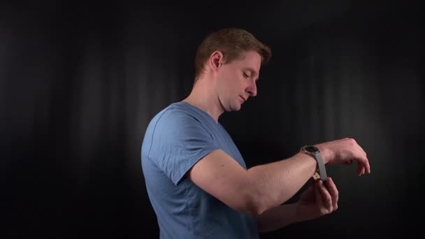 Seorang Pemuda Bergaya Sengaja Mengencangkan Sebuah Arloji Elegan Pergelangan Tangannya — Stok Video
