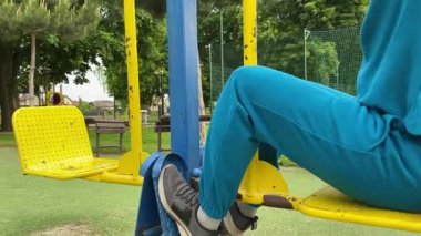 A dedicated young athlete puts in the hard work, vigorously training on gym equipment outdoors to prepare his body. He builds strength and endurance before hitting the field or court for competition