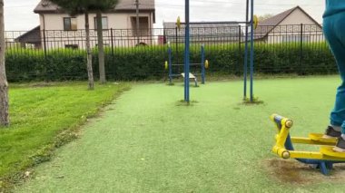 A dedicated young athlete puts in the hard work, vigorously training on gym equipment outdoors to prepare his body. He builds strength and endurance before hitting the field or court for competition