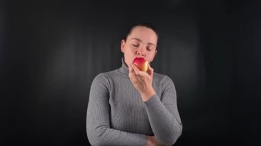 Çekici bir portre. Gri bir süveter giyen güzel bir kadın. Pürüzsüz, siyah bir arka planda izole edilmiş. Yaşam tarzı, moda ya da aşçılık